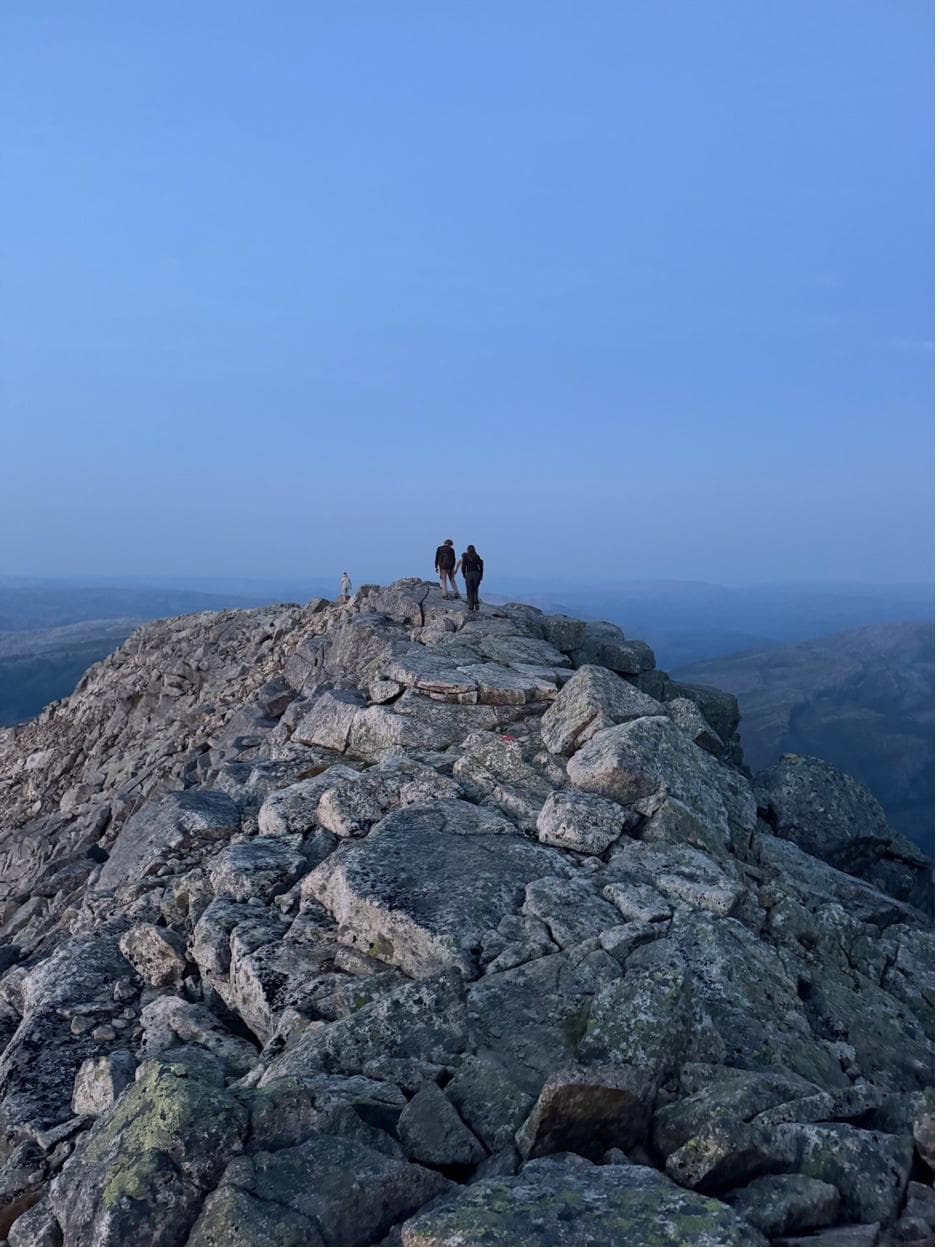 Hikers on rocky mountain summit ridge